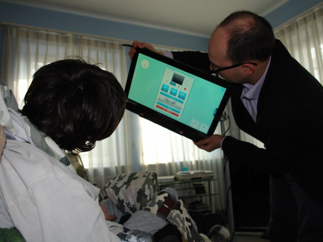 Osoba z niepełnosprawnością korzysta z monitora Cybereye, obsługiwanego przez technika