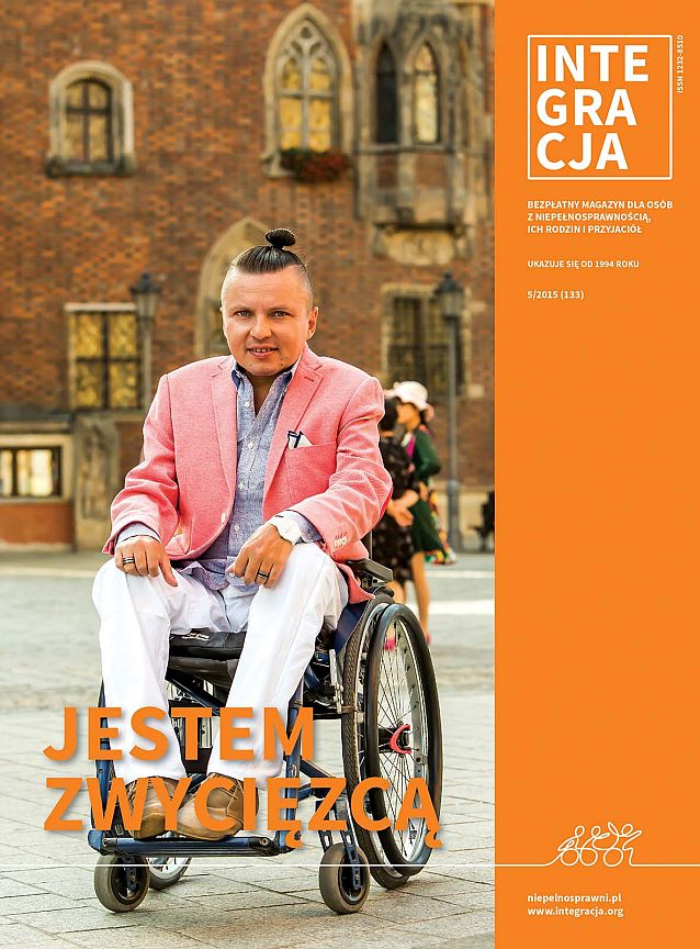 Okładka magazynu Integracja. Zdjęcie elegancko ubranego Bartłomieja Skrzyńskiego siedzącego na wózku na wrocławskim rynku. Podpis: jestem zwycięzcą