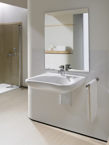 umywalka i lustro, umieszczone na odpowiedniej wysokości dla osób z niepełnosprawnością, w tle widać prysznic