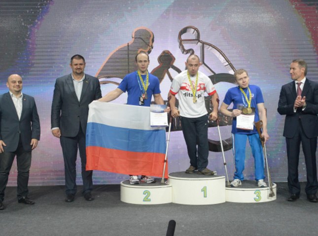 Maciej Gralak ze złotym medalem stoi na podium razem z Rosjanami, którzy wygrali srebro i brąz