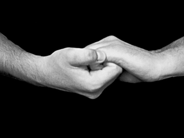 dwie dłonie złączone ze sobą, przedstawiające coś w języku migowym