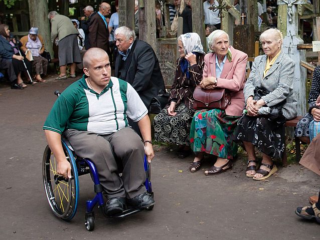mężczyzna na wózku wśród starszych osób