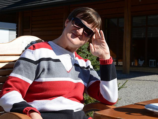 Agnieszka Skomorow siedzi uśmiechnięta przy stoliku