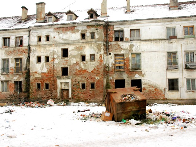 stary, zniszczony budynek, obok kontener, wszędzie śmieci