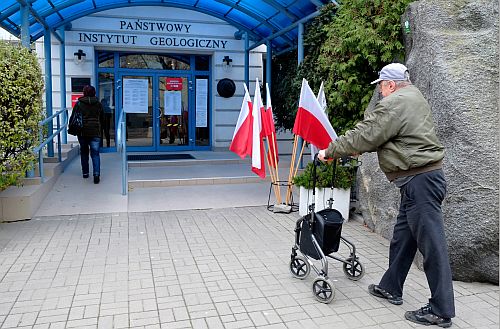 Mężczyzna z chodzikiem przed wejście do budynku okręgowej komisji wyborczej