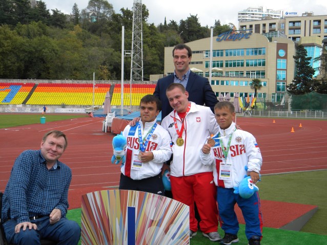 Bartosz Tyszkowski ze złotym medalem stoi na podium obok Rosjan