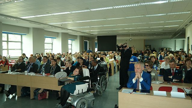 Sala wykładowa pełna ludzi, w tym osób na wózkach