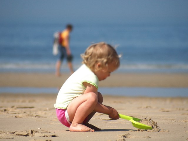 dziecko na plaży bawi się łopatką