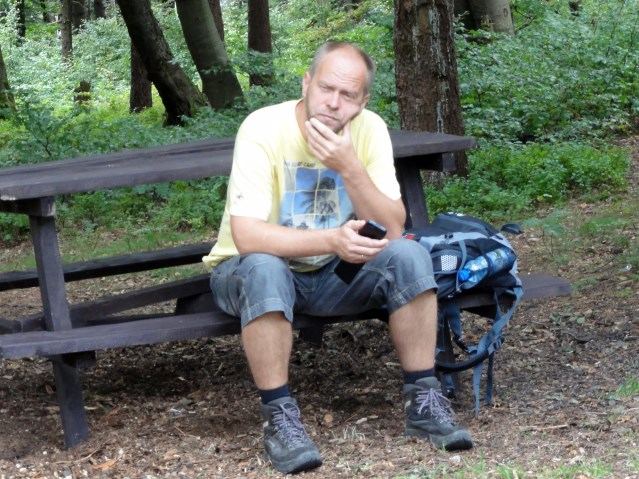 Jan Szuster siedzi na ławce w górach