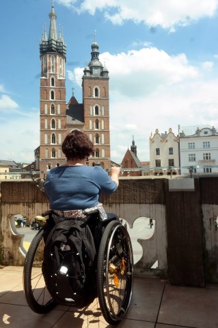 kobieta na wózku na tle kościoła mariackiego