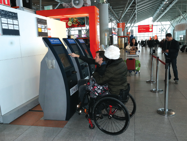 para na wózkach dokonuje samodzielnego check-in na lotnisku