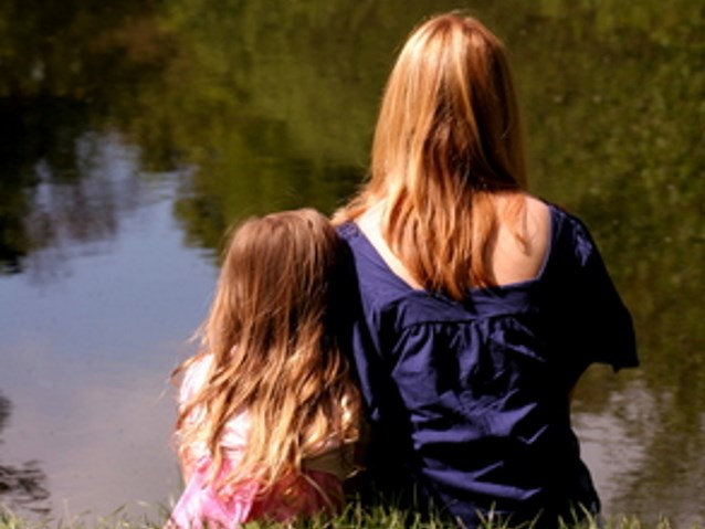matka i córka siedzą tyłem do odbiorcy, oglądają jezioro. Obie mają długie włosy