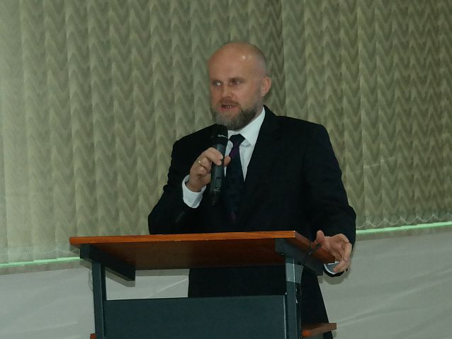 Minister Krzysztof Łanda na mównicy z mikrofonem