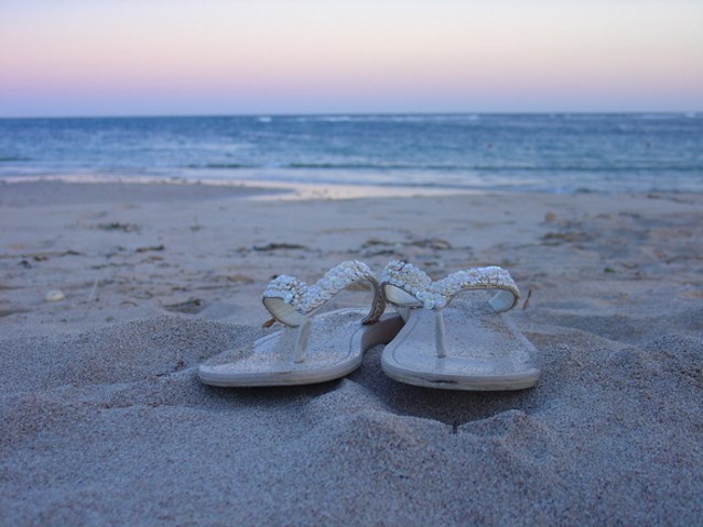 buty japonki zostawione na plaży, w tle morze