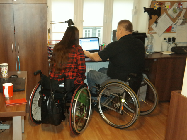 dwie osoby na wózkach pracują przy komputerze