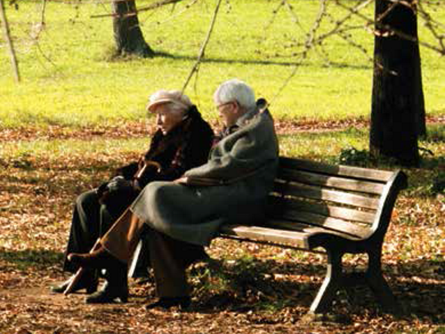 starsza kobieta i mężczyzna siedzą na ławce w parku