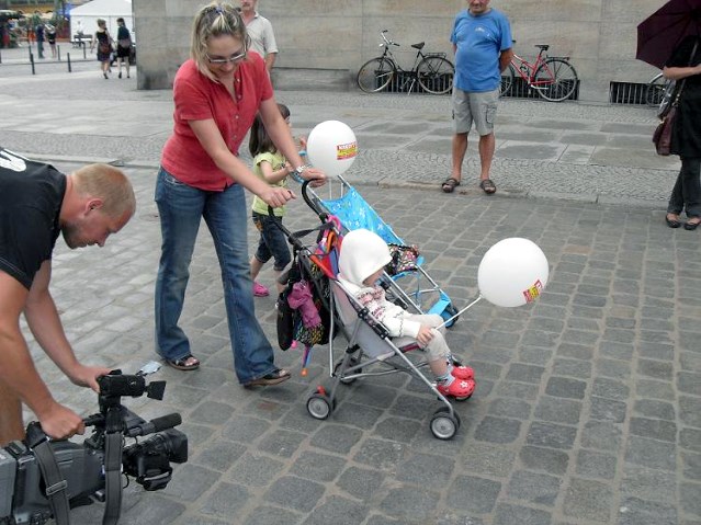 kobieta z małym dzieckiem na wózku idąca po szpilkostradzie