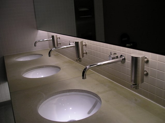 trzy umywalki i lustro w publicznej toalecie