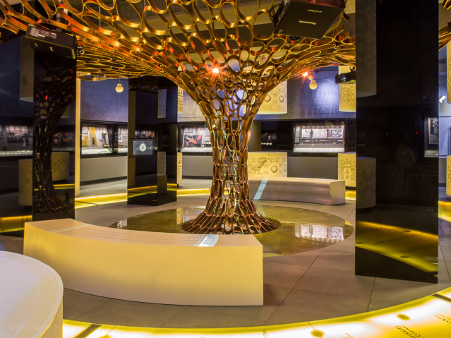 jakby drzewo zrobione z kółek, stoi w centrum sali muzealnej