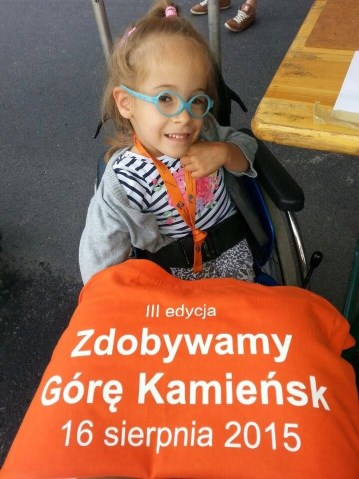 dziewczynka na wózku z koszulką Zdobywamy Górę Kamieńsk