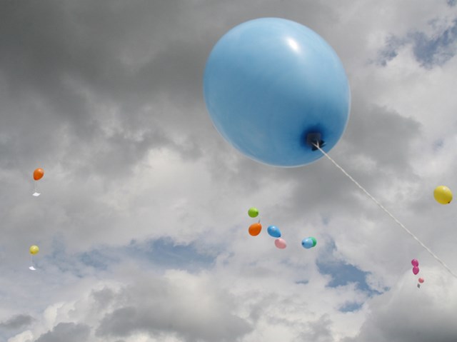 niebieski balon na tle zachmurzonego nieba