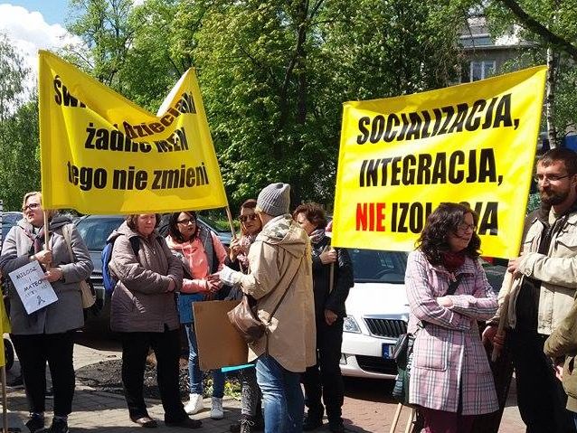 Manifestanci trzymają transparenty. Na jednym z nich napis: socjalizacja, integracja, nie izolacja