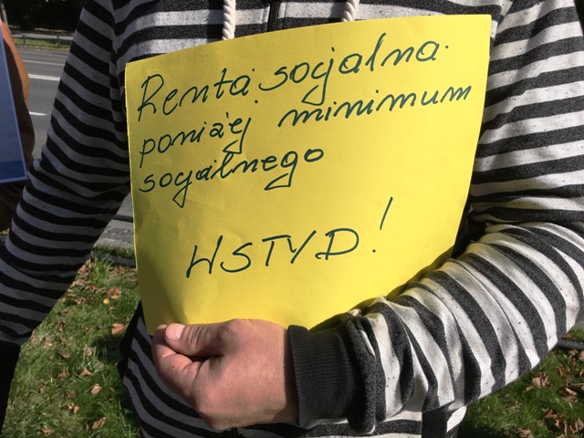 mężczyzna trzyma kartkę z napisem: renta socjalna poniżej minimum socjalnego - wstyd!