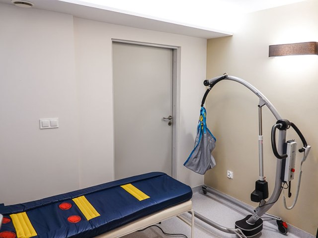 ustroń łóżko do terapii w pokoju z niebieskim materacem i sprzęt specjalistyczny