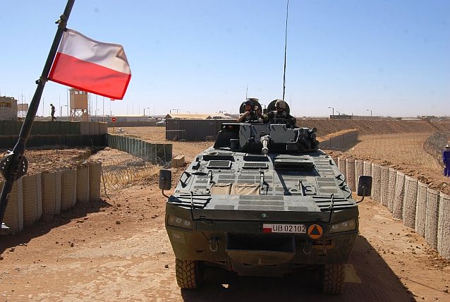 Transporter opancerzony Rosomak wyjeżdża z polskiej bazy zlokalizowanej w pustynnym terenie