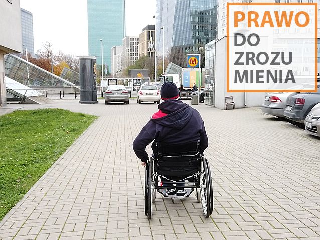 Mężczyzna na wózku na chodniku w centrum Warszawy. Na zdjęciu napis: prawo do zrozumienia