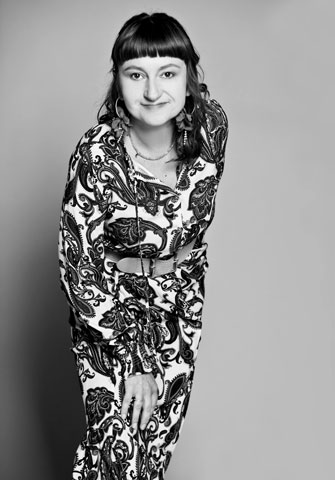 zdjęcie Agaty Jabłonowskiej-Turkiewicz w długich kolczykach i długiej sukience we wzory