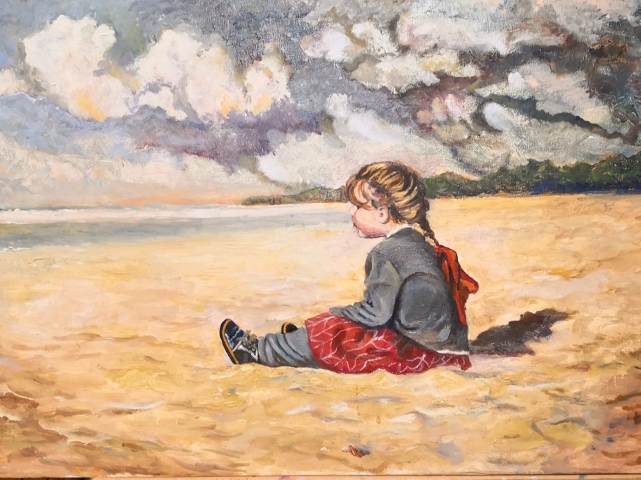 obraz dziewczynki siedzącej na plaży przed nią morze