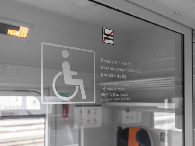 szyba przedziału z napisem przedział dla osób o ograniczonej możliwości poruszania się z symbolem osoby na wózku