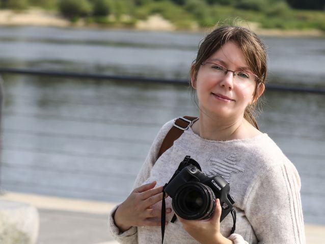 Ilona Berezowska pozuje do zdjęcia trzymając aparat