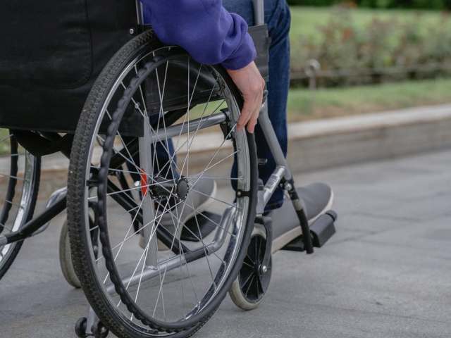 Osoba siedząca na wózku inwalidzkim.