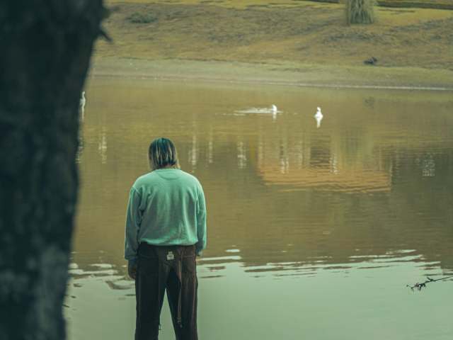 Mężczyzna stojący przy jeziorze.