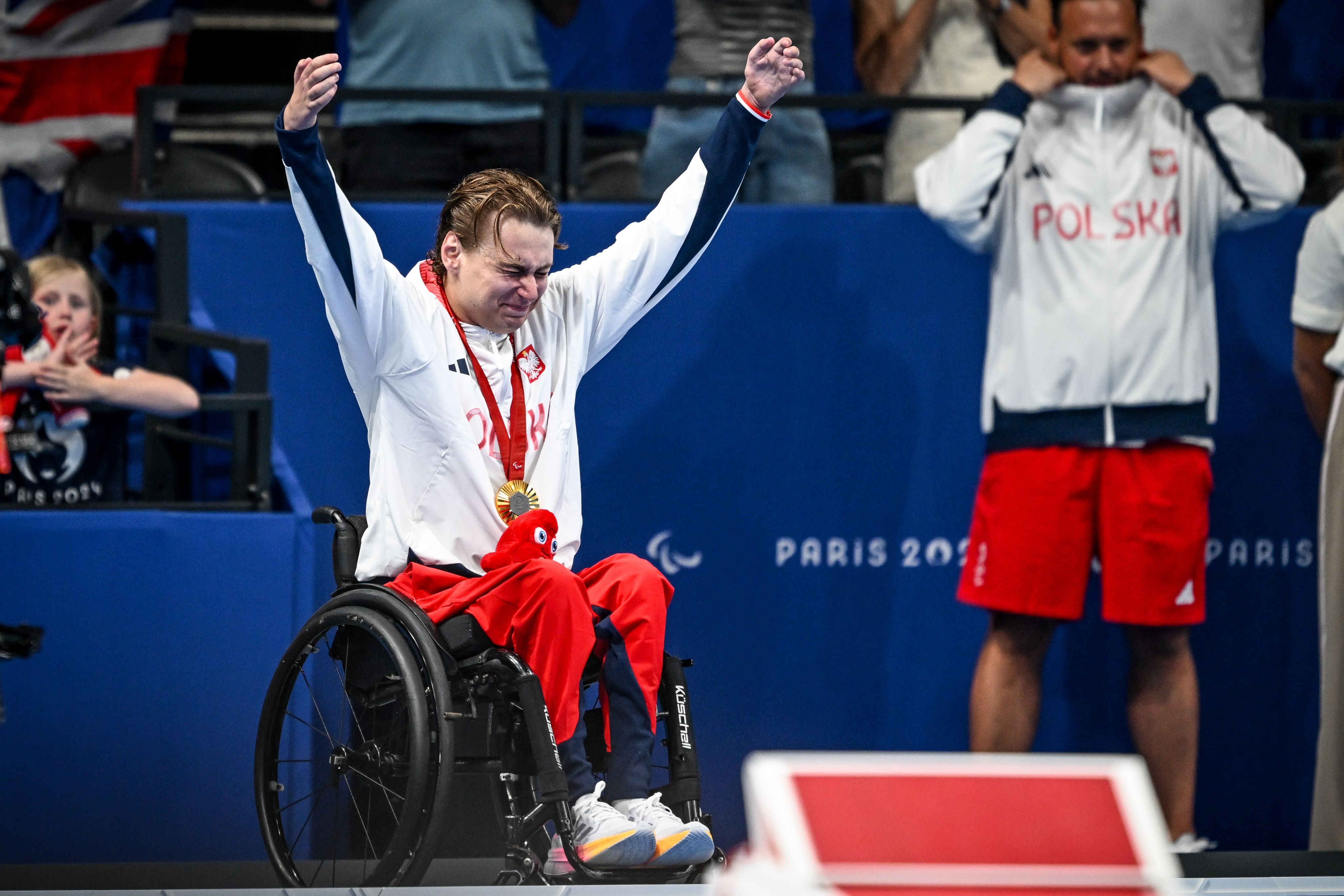 Kamil Otowski na podium cieszy się ze złotego medalu. 