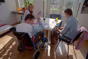 rodzina z dzieckiem z niepełnosprawnością przy stoliku w salonie