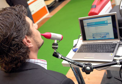 Mężczyzna pracuje na komputerze oddechem za pomocą specjalnego urządzenia