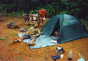Dave Barr leży przed namiotem na kocyku/ plandece