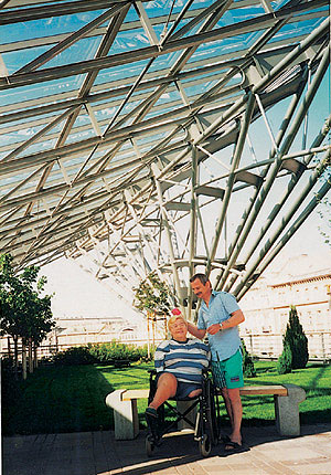 kobieta na wózku i mężczyzna pozują w modernistycznym ogrodzie