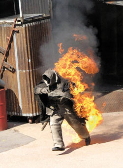 zdjęcie: płonący człowiek w ochronnym kombinezonie
