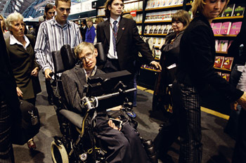 zdjęcie: Stephen Hawking z asystentem idą przez korytarz pełen ludzi