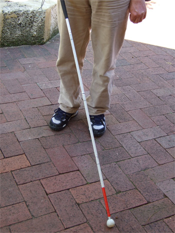 Na zdjęciu: osoba niewidoma z białą laską