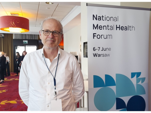 Dr Rene Keet, szczuply mężczyzna w średnim wieku stoi przy banerze Ogólnopolskiego Forum Zdrowia Psychicznego.
